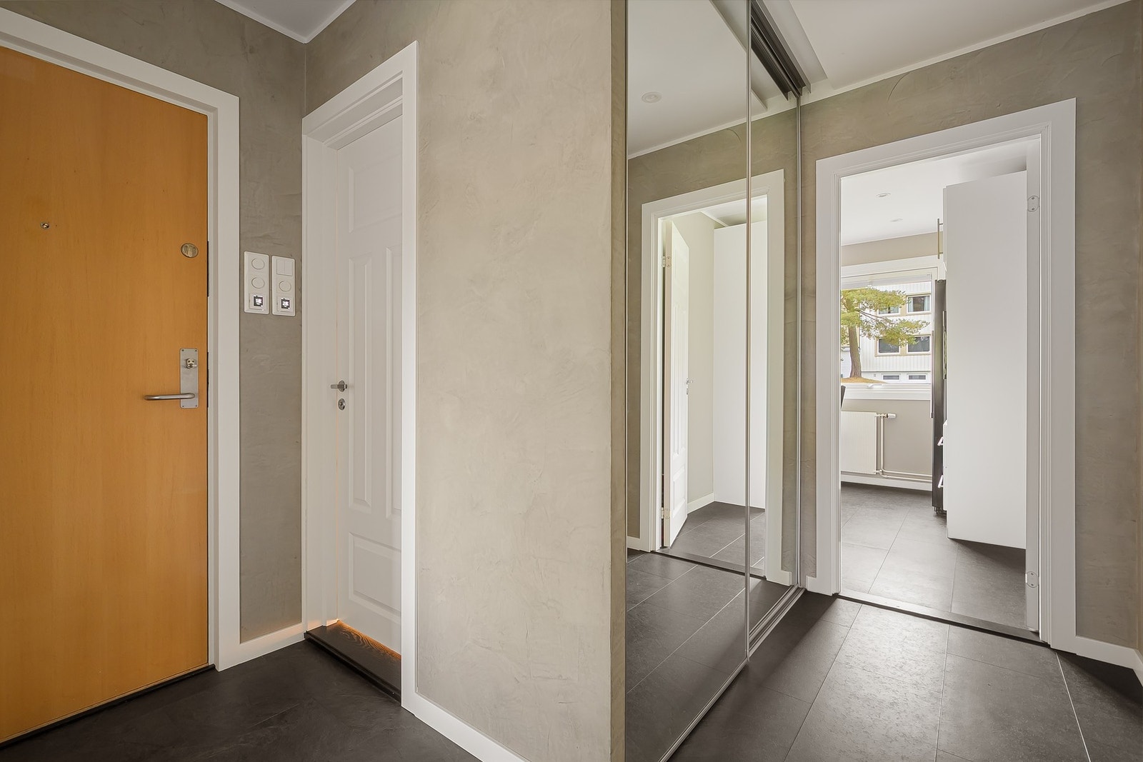 Innbydende entré med speilbelagt skyvedørsgarderobe Galleribilde