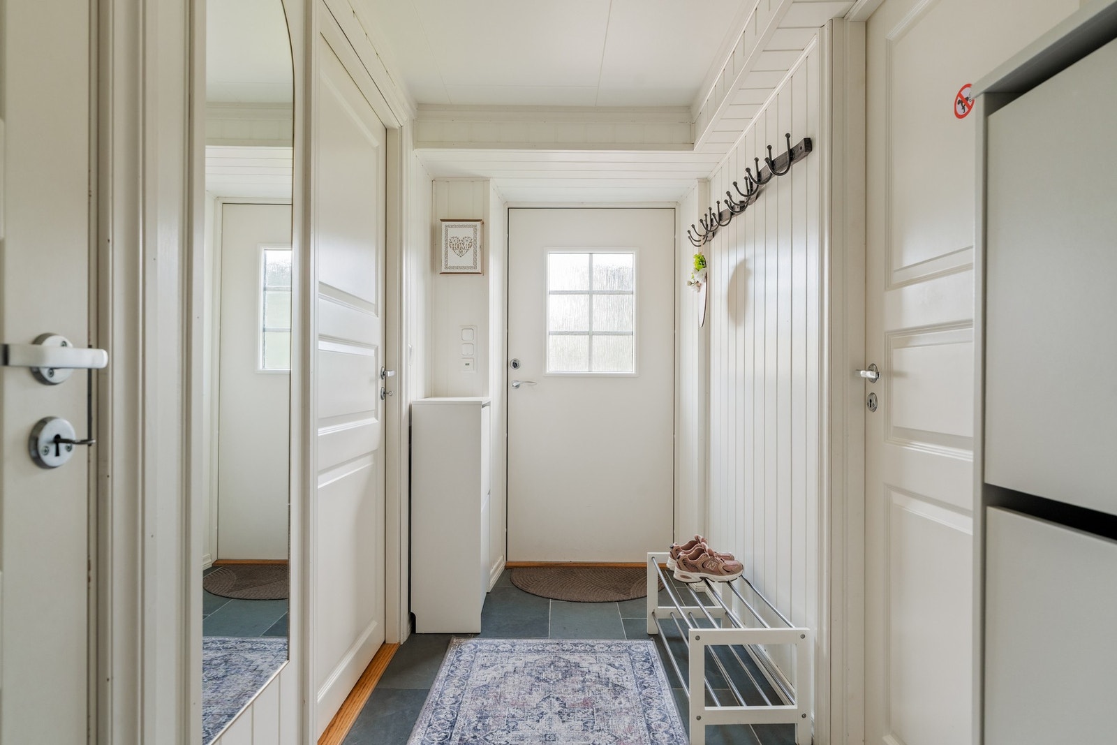 Velkommen inn! Leiligheten har en lang entré med plass til garderobeløsning, yttertøy og sko. Galleribilde