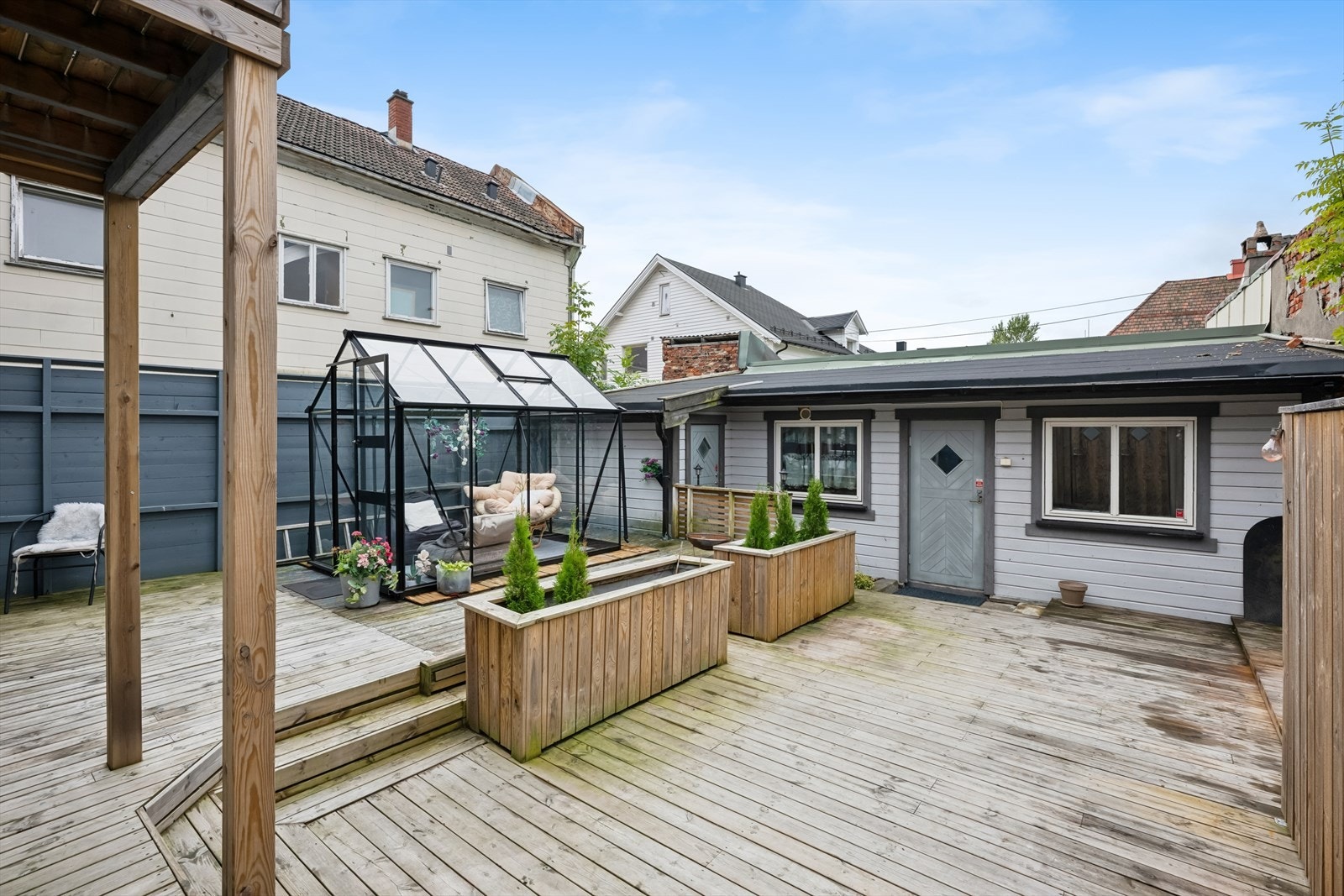Eiendommen byr på et hyggelig og skjermet uteområde i form av et innbydende indre gårdsrom/bakgård med stor treplatting, drivhus og plantekasser. Galleribilde