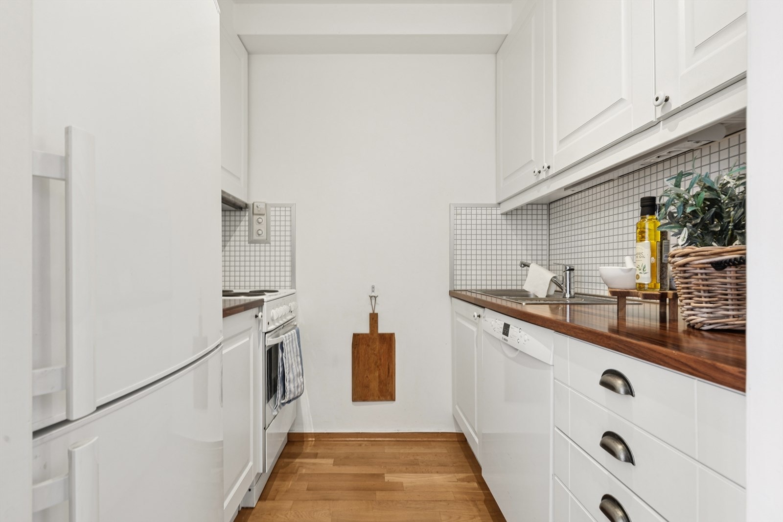 Kjøkkeninnredning fra 2010 med slette fronter, laminert benkeplate og fliseplater på vegg. Galleribilde