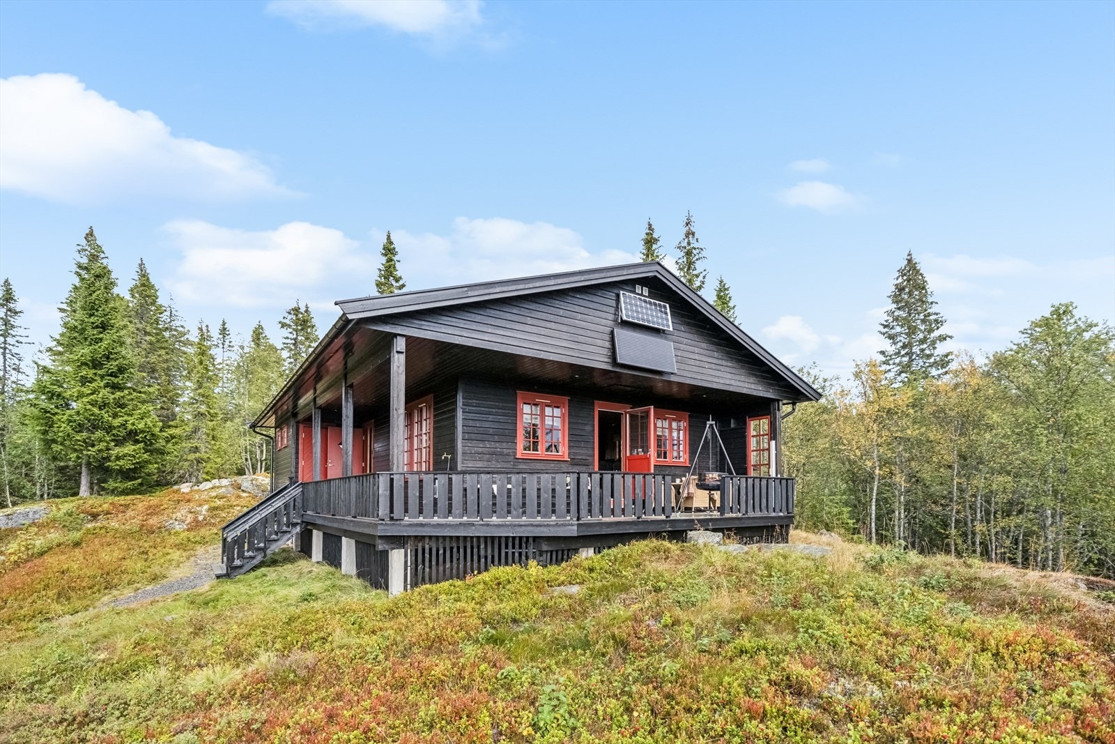 Hytta er oppført i tradisjonell stil og glir naturlig inn i terrenget. Galleribilde