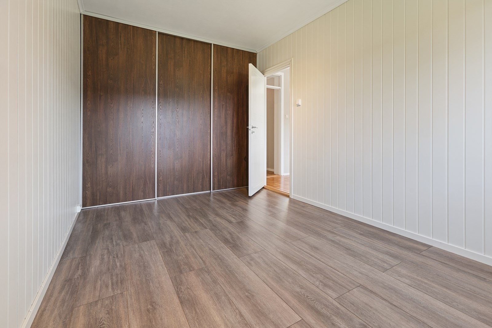 Hovedsoverom med panelkledde vegger og garderobeskap med skyvedører. Galleribilde
