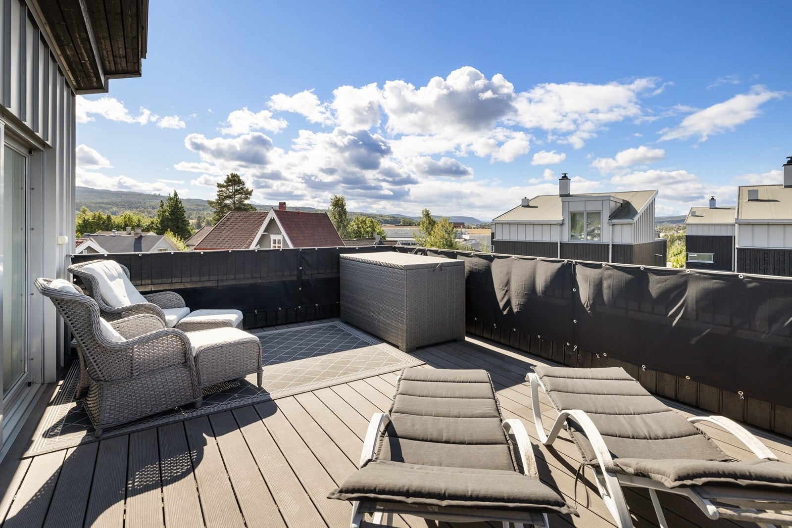 Stor takterrasse med komposittdekke, stålrekkverk og flott utsikt over området. Galleribilde