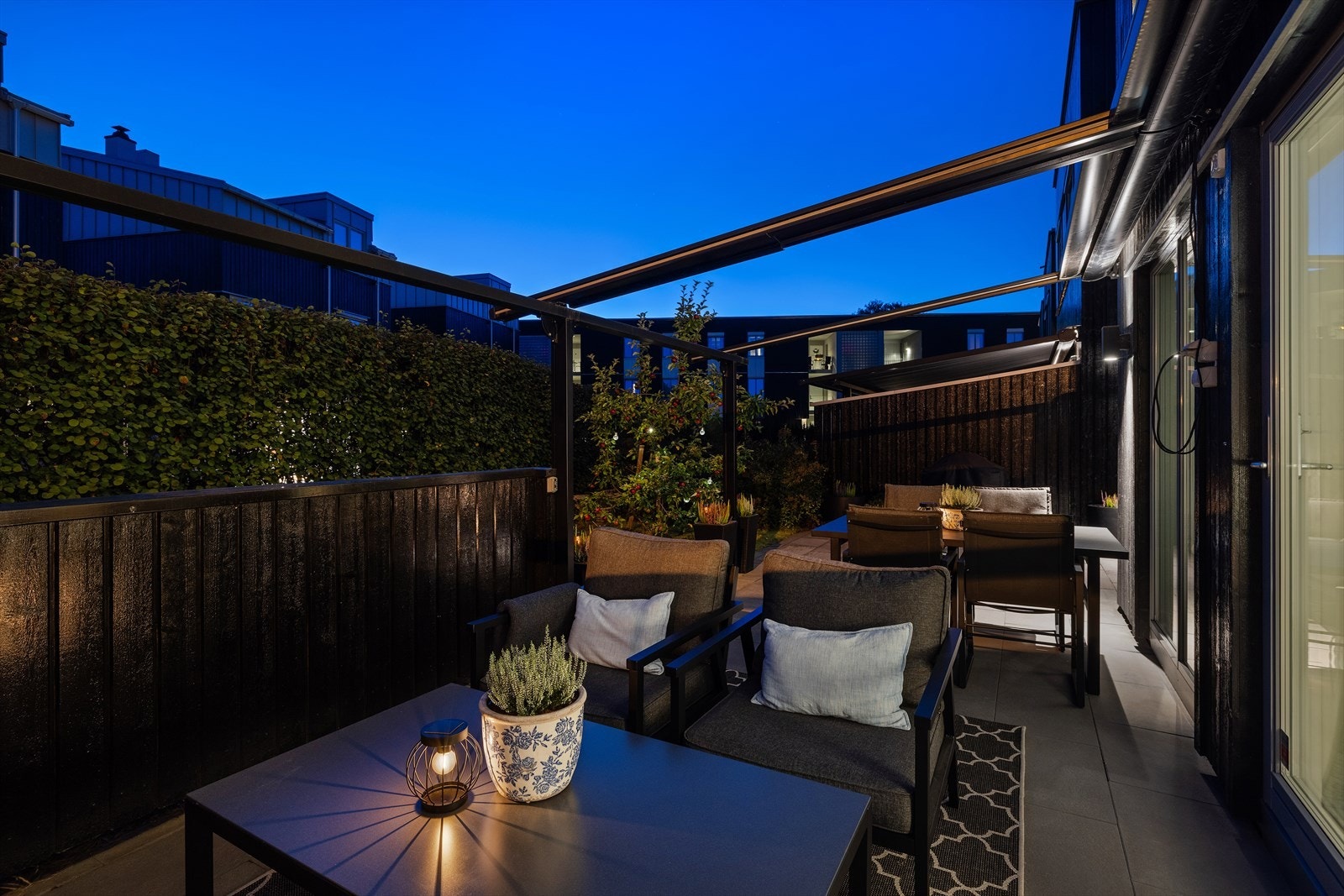 Stemningsfull markterrasse i kveldslys med sittegruppe og integrert utebelysning. Galleribilde