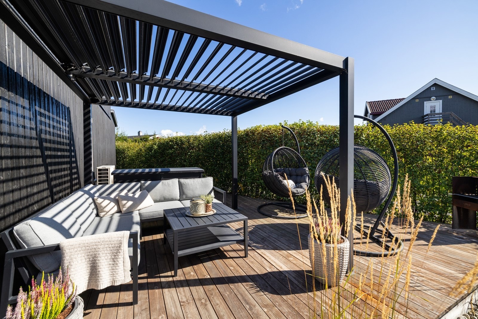 Bygget pergola over treterrasse gir et lunt og skjermet oppholdssted i hagen. Galleribilde
