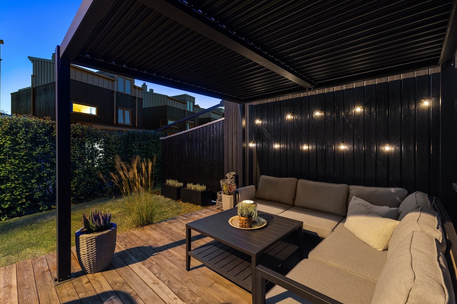 Skjermet hjørne av hagen med treterrasse og sittegruppe. Galleribilde