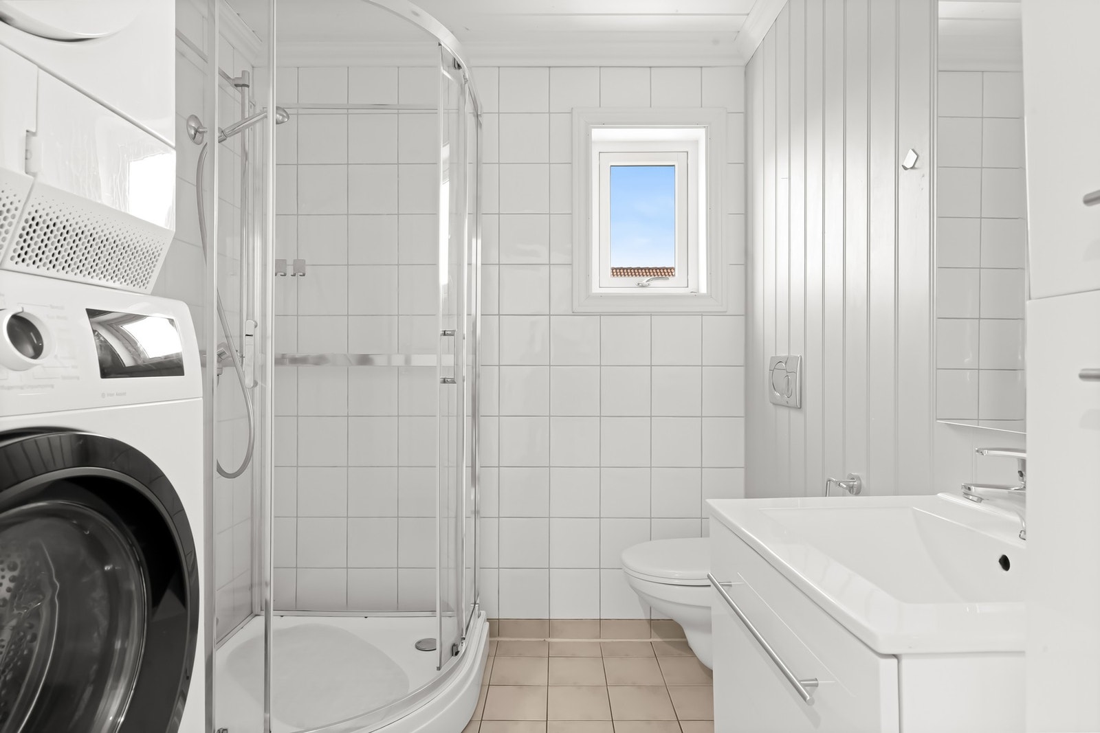 Bad/vaskerom med dusjkabinett, servantinnredning og gulvvarme. Galleribilde