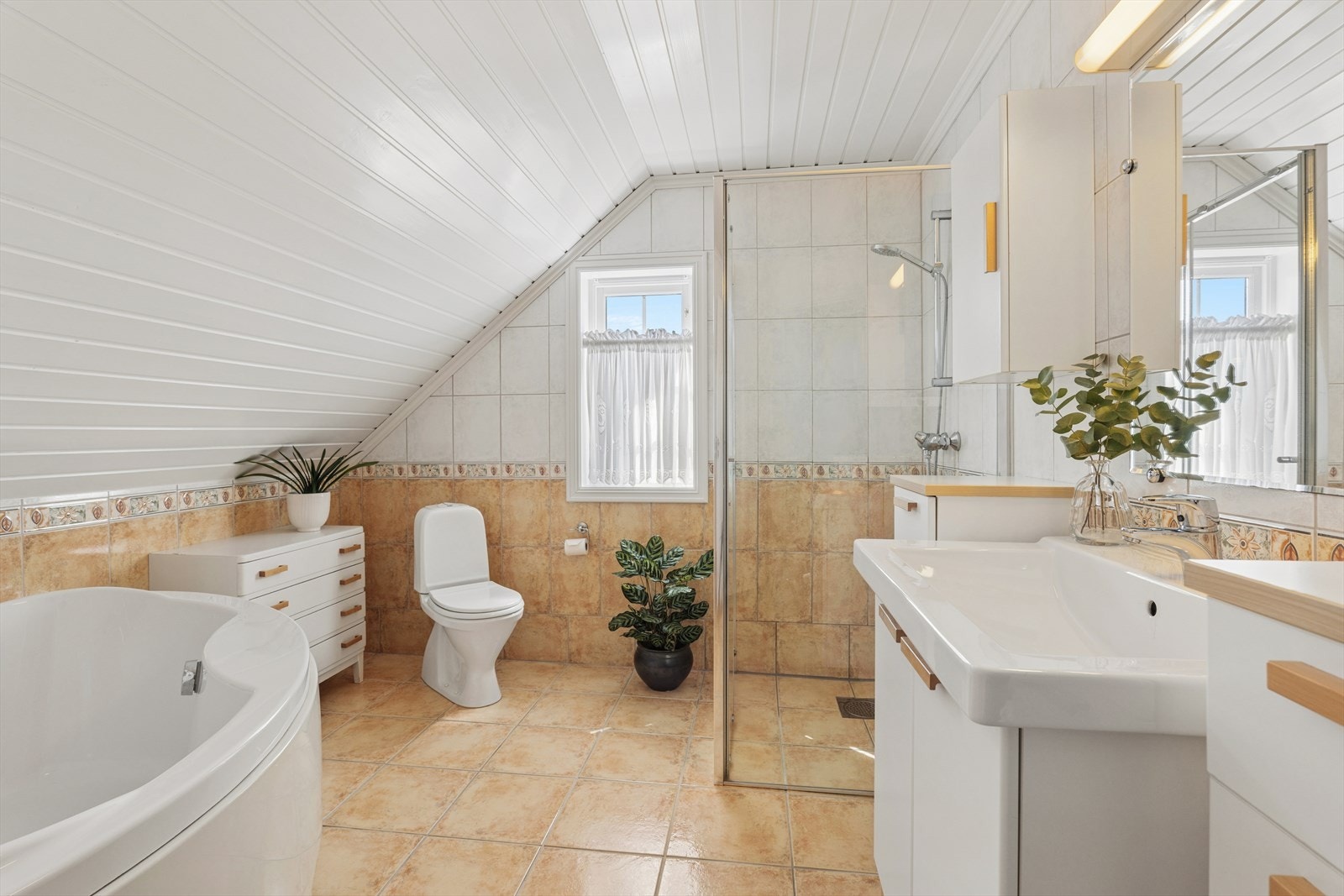 Badet har både badekar og separat dusj, samt praktisk baderomsinnredning Galleribilde