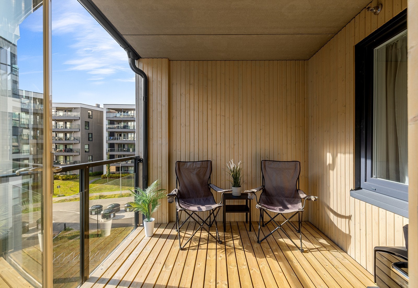 Koselig og overbygget balkong på ca. 6 kvm med flott tregulv, lune trevegger og moderne glassrekkverk. Her er det god plass til en hyggelig sittegruppe hvor du kan nyte fine dager. Galleribilde