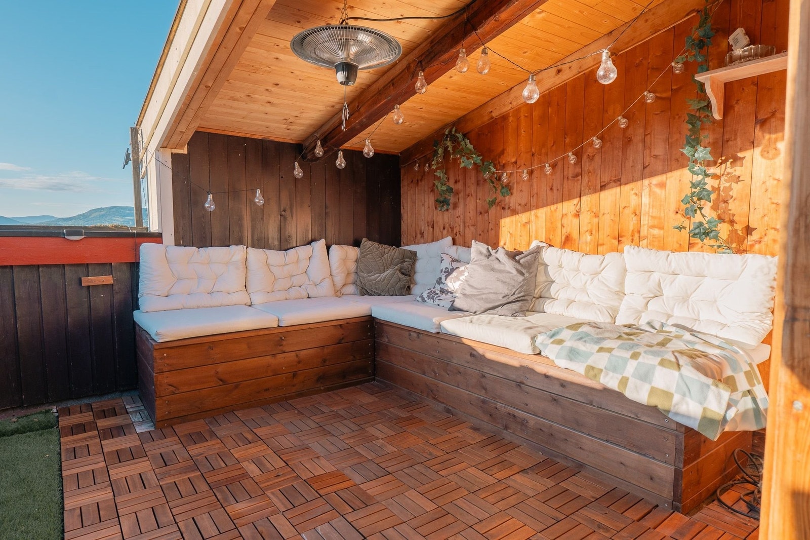 Fantastisk, overbygd takterrasse på 10m² – komplett med gode solforhold, sofa med oppbevaring og koselig belysning. Galleribilde
