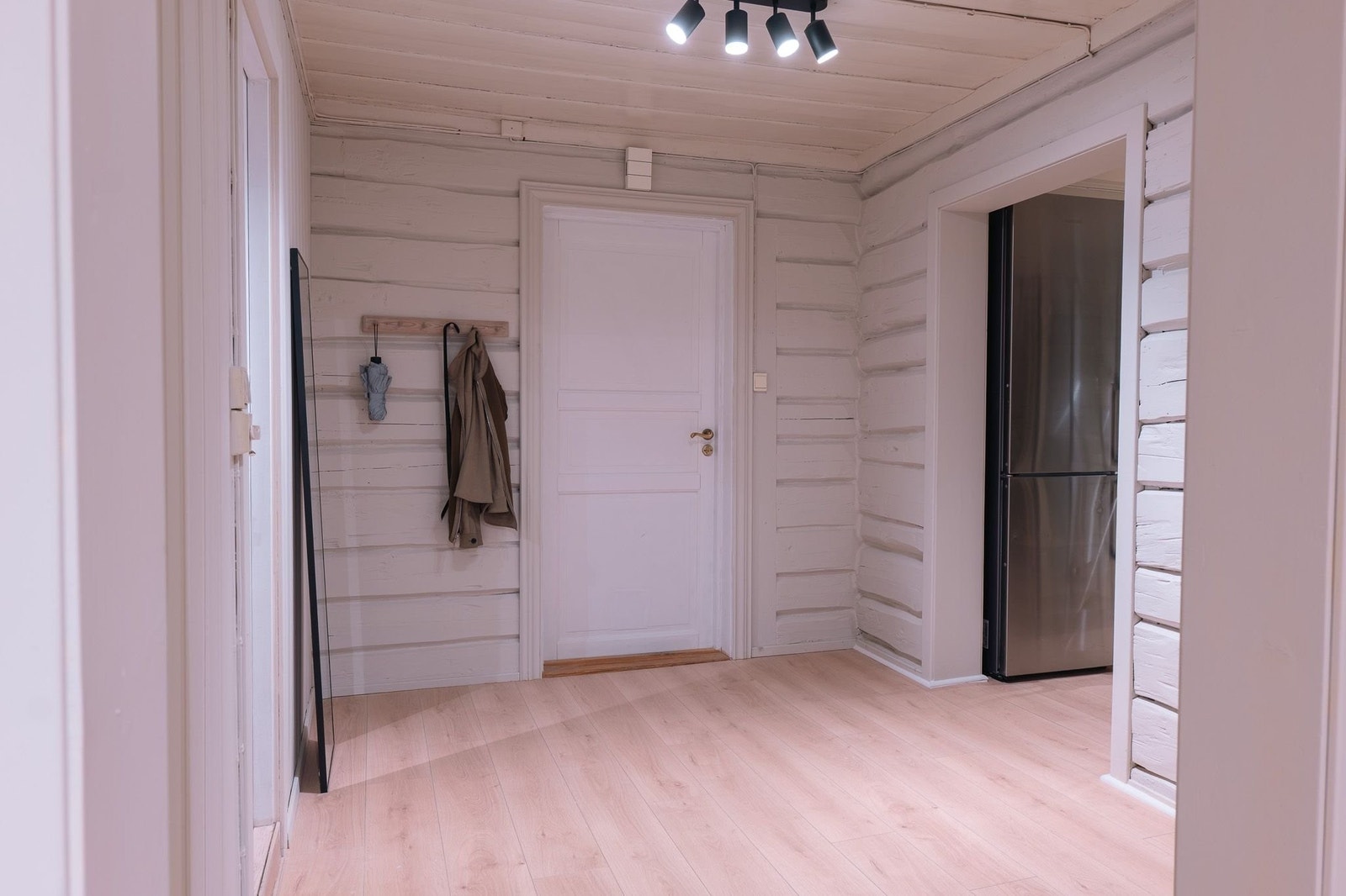 Innbydende og romslig entré med god plass til avheng av yttertøy og skooppbevaring, preget av lune, hvitmalte tømmerdetaljer. Galleribilde