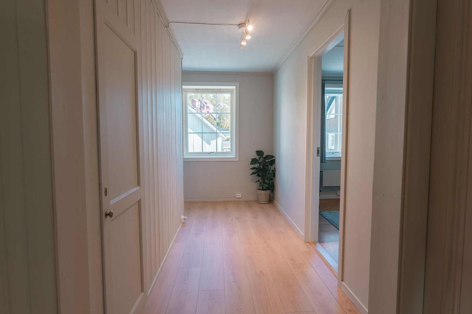 Lys og luftig gang med naturlig dagslys fra vinduet som skaper en åpen og trivelig gjennomgang mellom rommene. Galleribilde