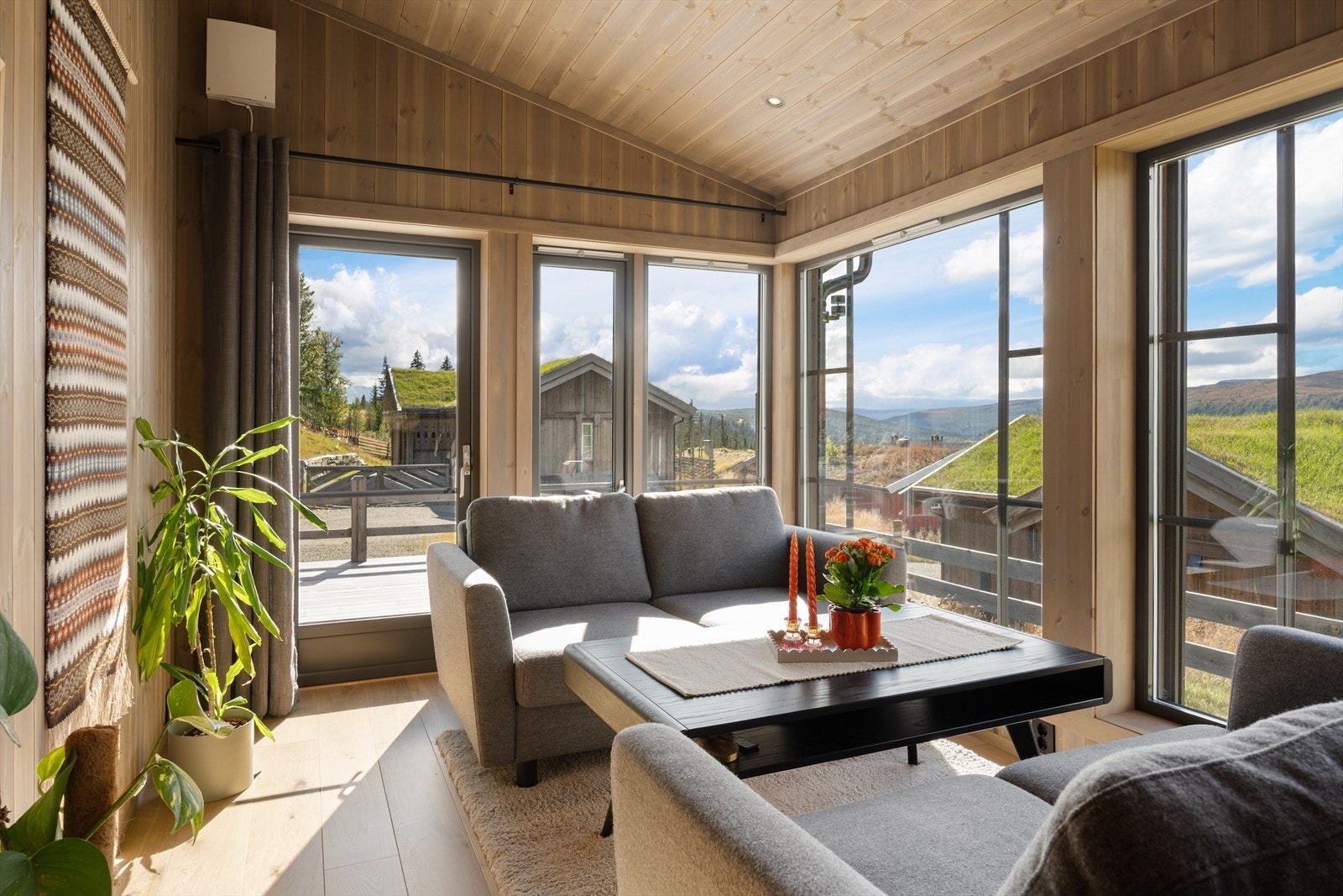 Stua har skråhimling, store vindusflater og direkte utgang til terrasse. Galleribilde