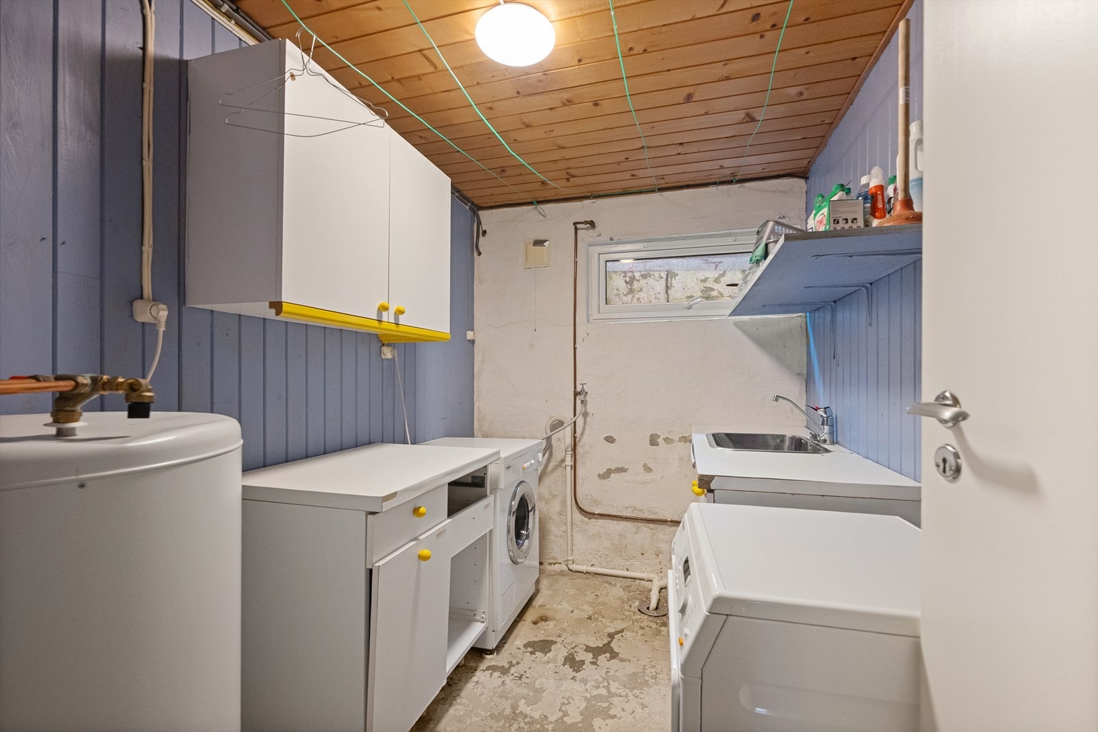 Praktisk vaskerom med opplegg for vaskemaskin, skyllekum og varmtvannsbereder. Galleribilde