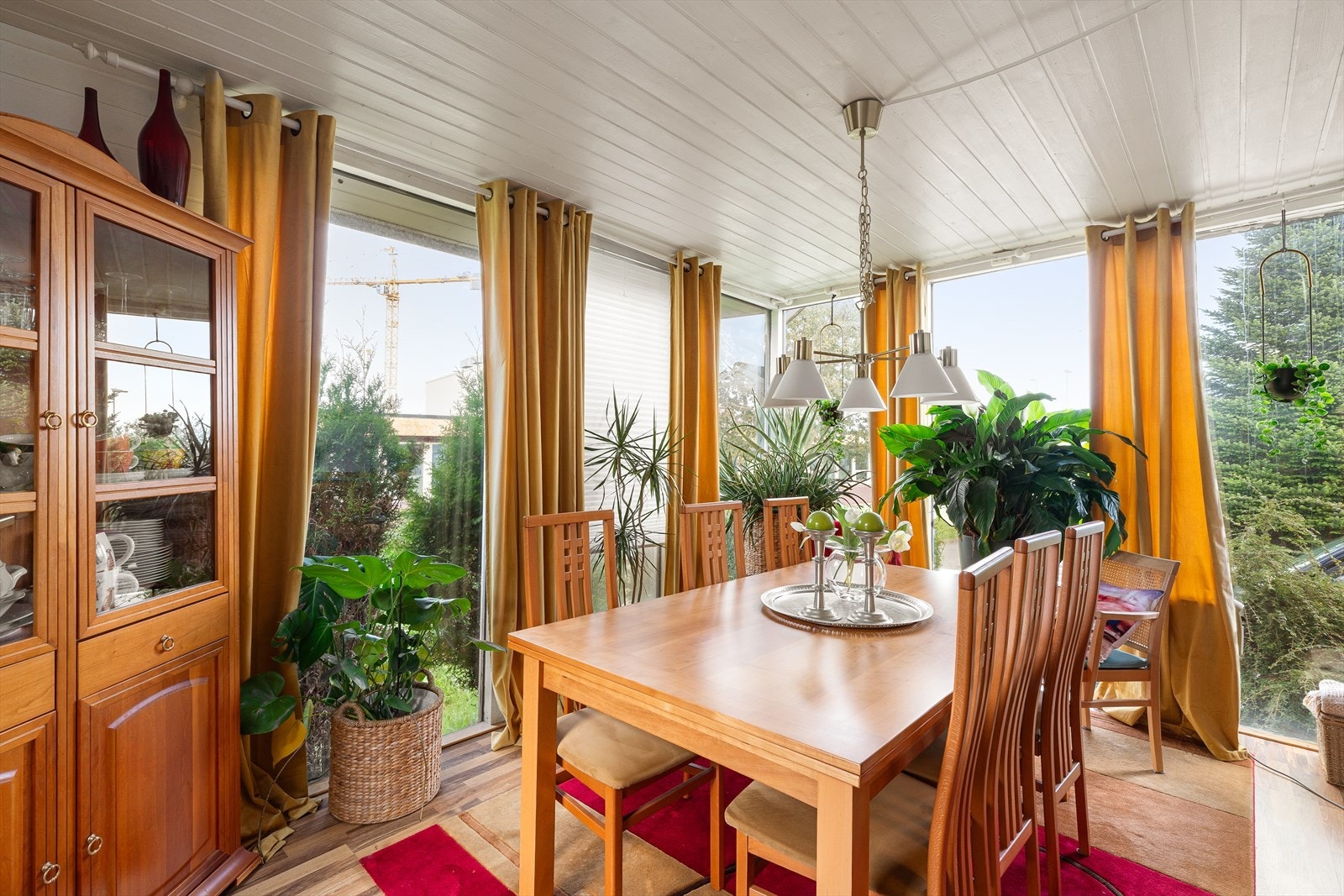 Innredet hagestue med store glassflater mot hagen. Galleribilde