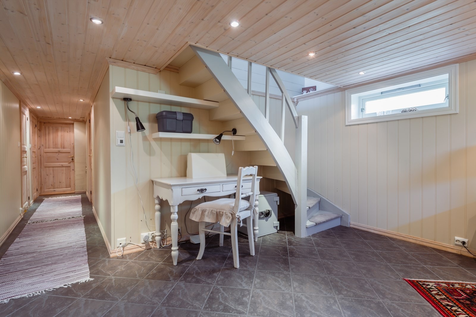 Trappen ned til kjelleren. En liten hjemmekontorstasjon er plassert under trappen, perfekt størrelse med plass til pult og hyller. Galleribilde