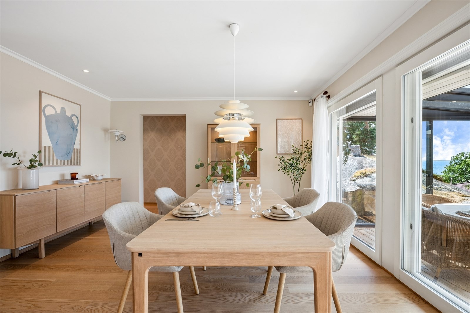 Store vindusflater og skyvedør til den innglassede verandaen gir rommet et flott lysinnslipp og en sømløs overgang mellom inne- og utearealene. Galleribilde