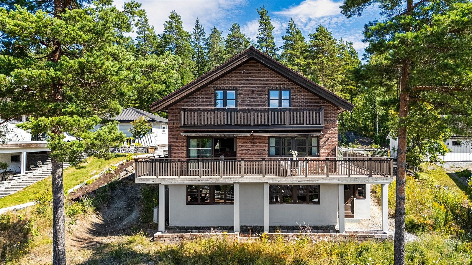 Boligen har en attraktiv beliggenhet på en høyde, med flott utsikt over skog og landskap, samtidig som den tilbyr rolige og familievennlige omgivelser. Galleribilde