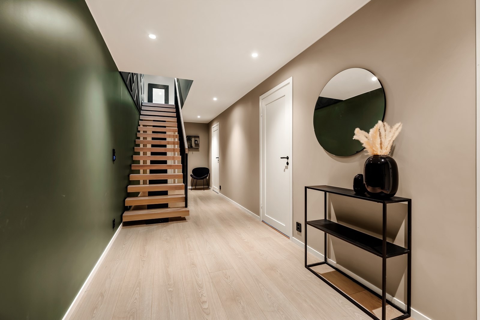 Trappen med trinn i tre og vange i stål leder ned til underetasjen. Galleribilde
