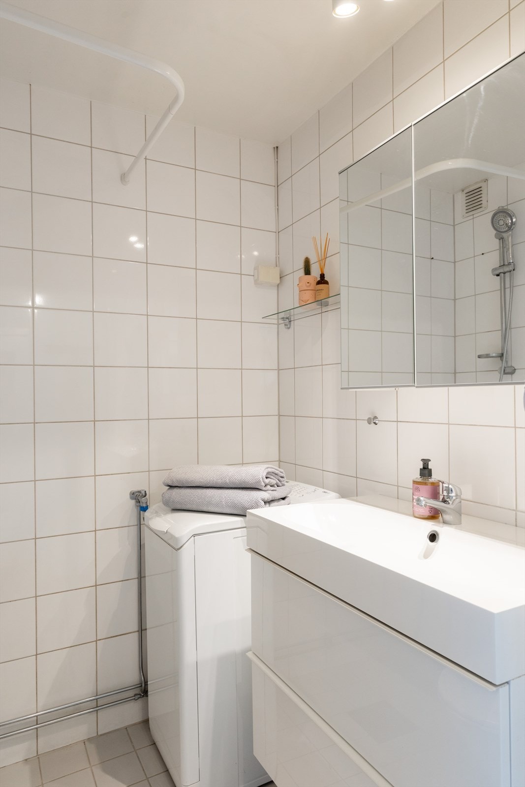 Badet er innredet med gulvstående toalett, servant med innredning og dusjhjørne med dusjforheng - videre er det opplegg for vaskemaksin! Galleribilde