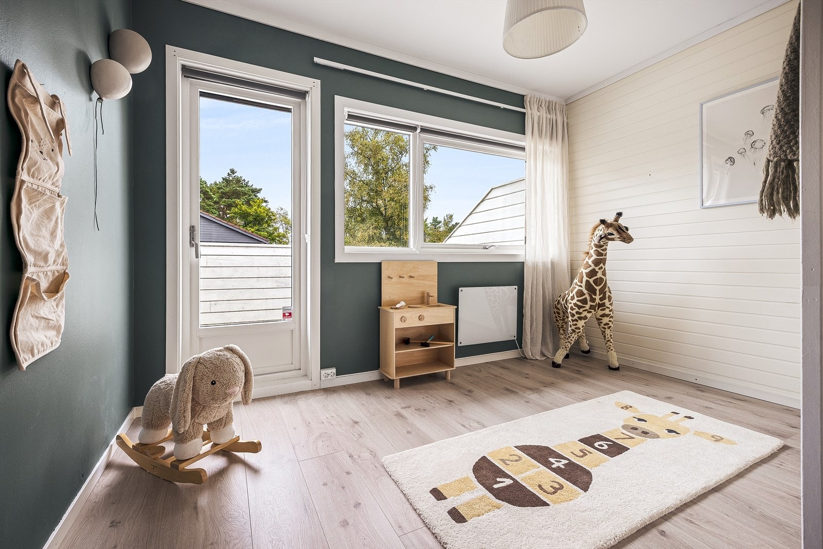 Rommet har lys laminat på gulv og vegger med malt platekledning og panel. Galleribilde