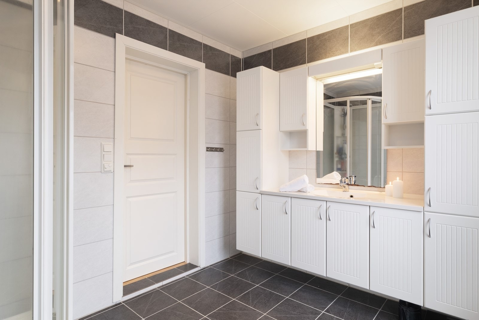 Badet er innreidd med baderomsmøbel med heildekkjande servant, toalett og dusjkabinett. Det er avtrekksvifte i veggen. Galleribilde