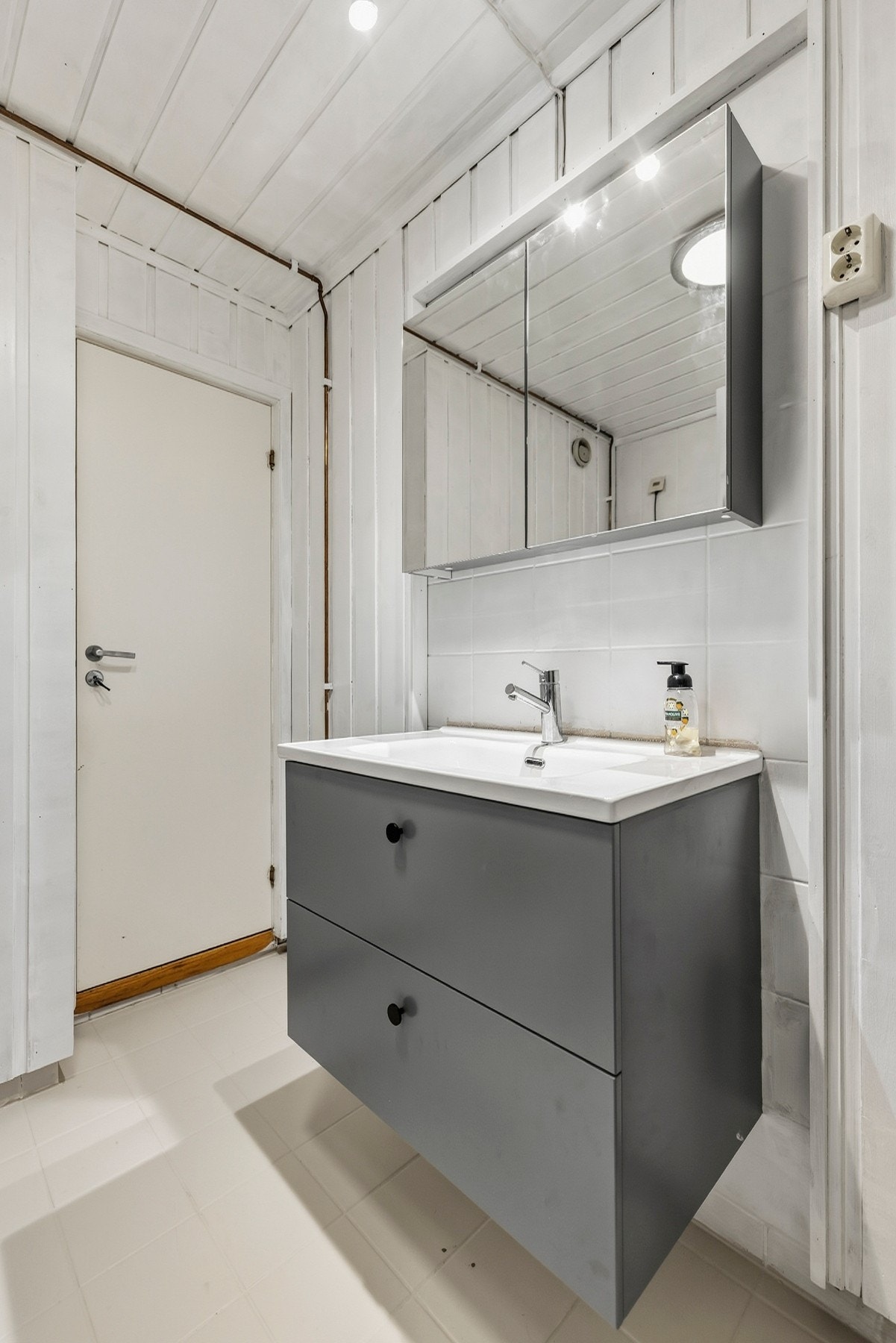 Badet har gulvstående servantskap og dusjkabinett. Galleribilde