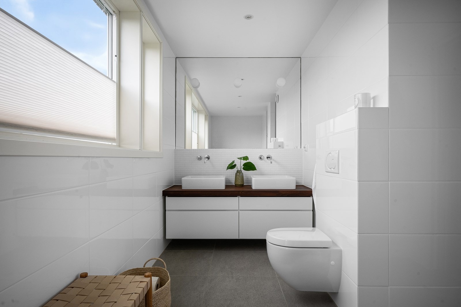 Et delikat og komplett baderom også i denne etg. To servanter for lett stell med flere samtidig. Kranen rett ut av veggen gir et stilrent uttrykk. Integrert speil i veggen med designbelysning. Mye naturlig lys med flere vinduer. Galleribilde