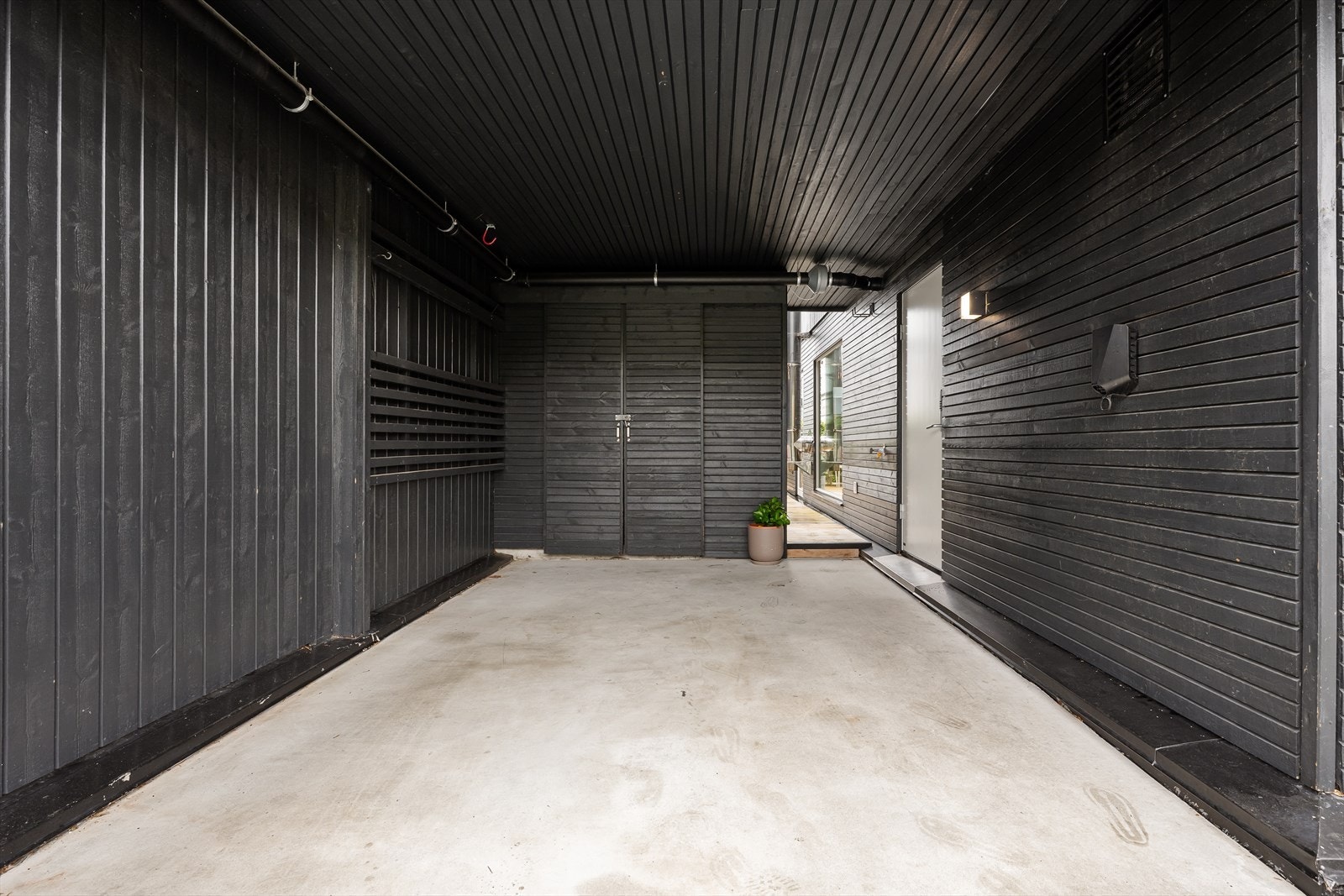 Carport med easee lader og bod i bakkant. Skyvedør som stenger av til terrassen. Tørrskodd inn til bi-inngang. Plass til ekstra bil i front med hovedentre. Galleribilde
