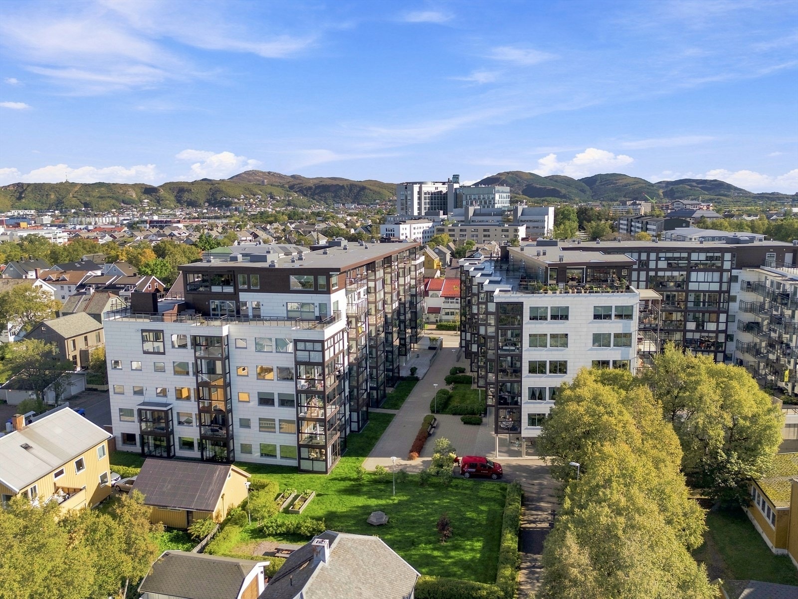 Skjermet gårdsrom mellom byggene med grøntarealer og sitteplasser. Galleribilde