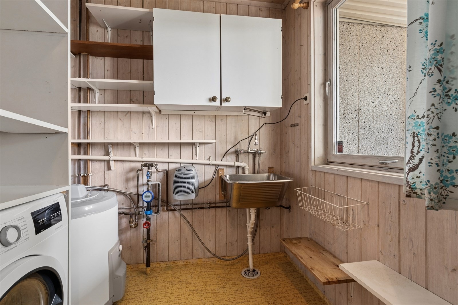 Praktisk vaskerom med opplegg for vaskemaskin, utslagsvask og varmtvannstank. Galleribilde