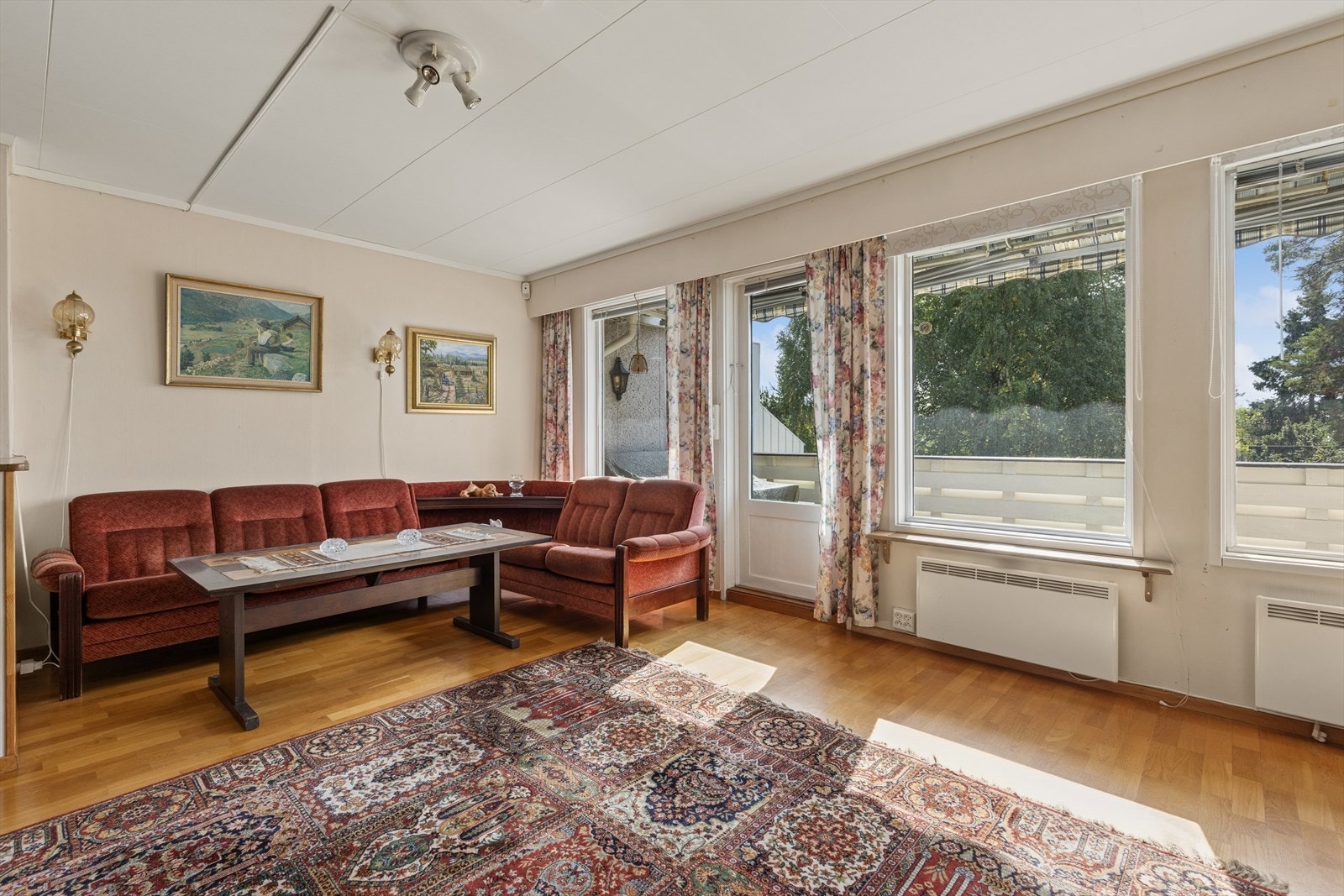Store vindusflater slipper inn rikelig med dagslys, med balkongdør like ved sofakroken. Galleribilde