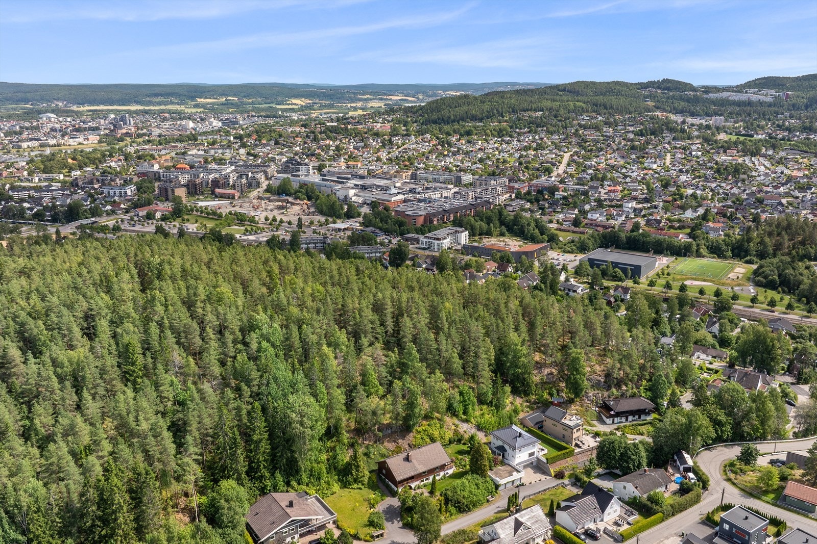Dronebilde. Eiendommen vender mot skogen og ligger tilbaketrukket fra Strømmen sentrum. Galleribilde