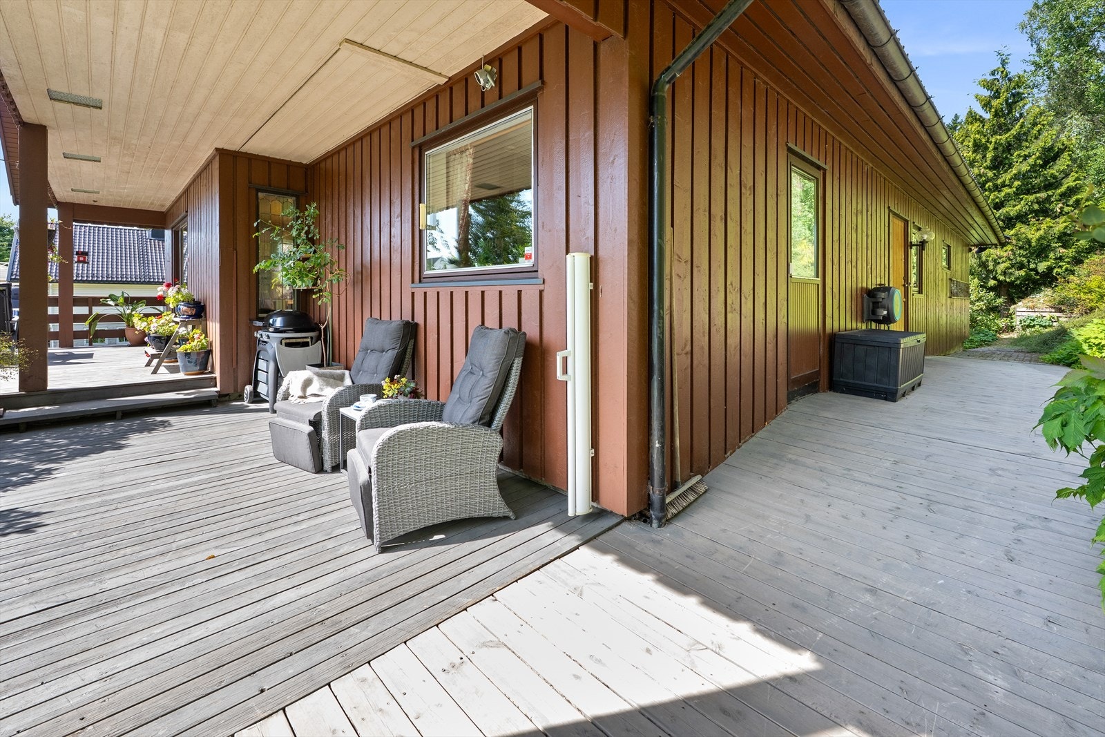 Fra hushjørnet ved kjøkkenet, med terrasse mot sør og videre platting og uteplass mot øst. Galleribilde