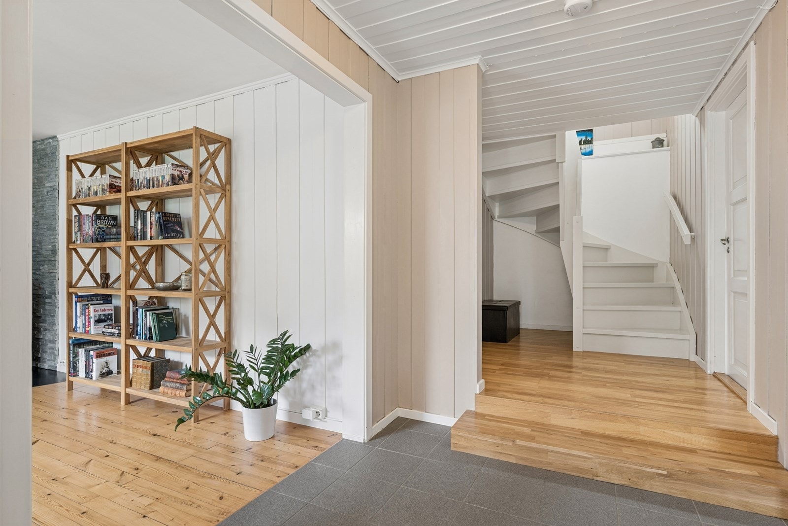 En romslig hall gir underetasjen en åpen og praktisk romfølelse, med god forbindelse mellom etasjens ulike rom. Galleribilde