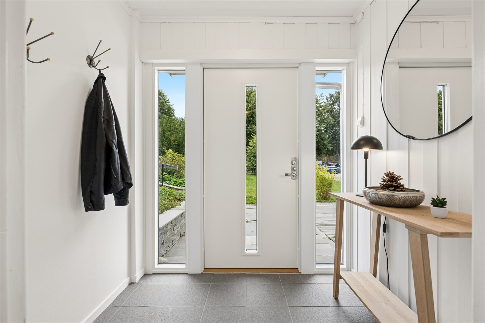 Velkommen inn! Den lyse entréen gir et fint førsteinntrykk, med vindusfelt rundt inngangsdøren som slipper inn godt med dagslys. Galleribilde