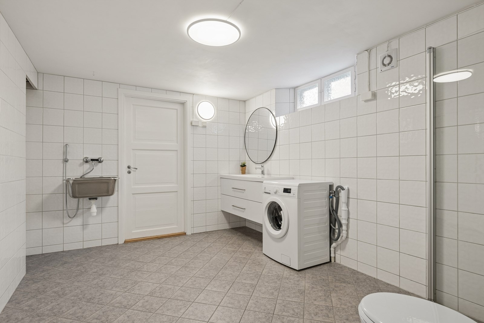 Underetasjen har et romslig bad/vaskerom med god plass til klesvask og praktiske løsninger i hverdagen. Galleribilde