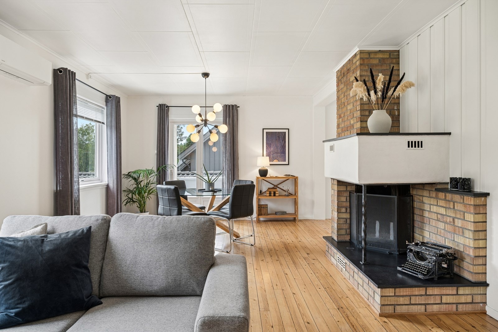 Den åpne peisen er et flott blikkfang i stuen. Fra spisestuedelen er det direkte utgang til verandaen og videre ned i hagen. Galleribilde