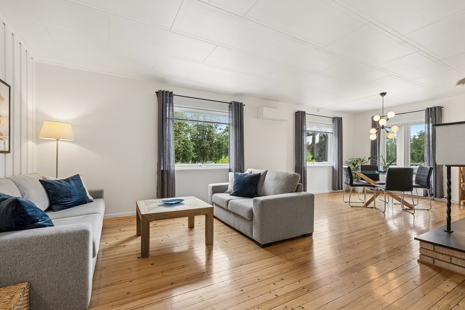 Her er det god plass til både sofagruppe og spisebord, de store vindusflatene gir et flott lysinnslipp og en luftig atmosfære. Galleribilde