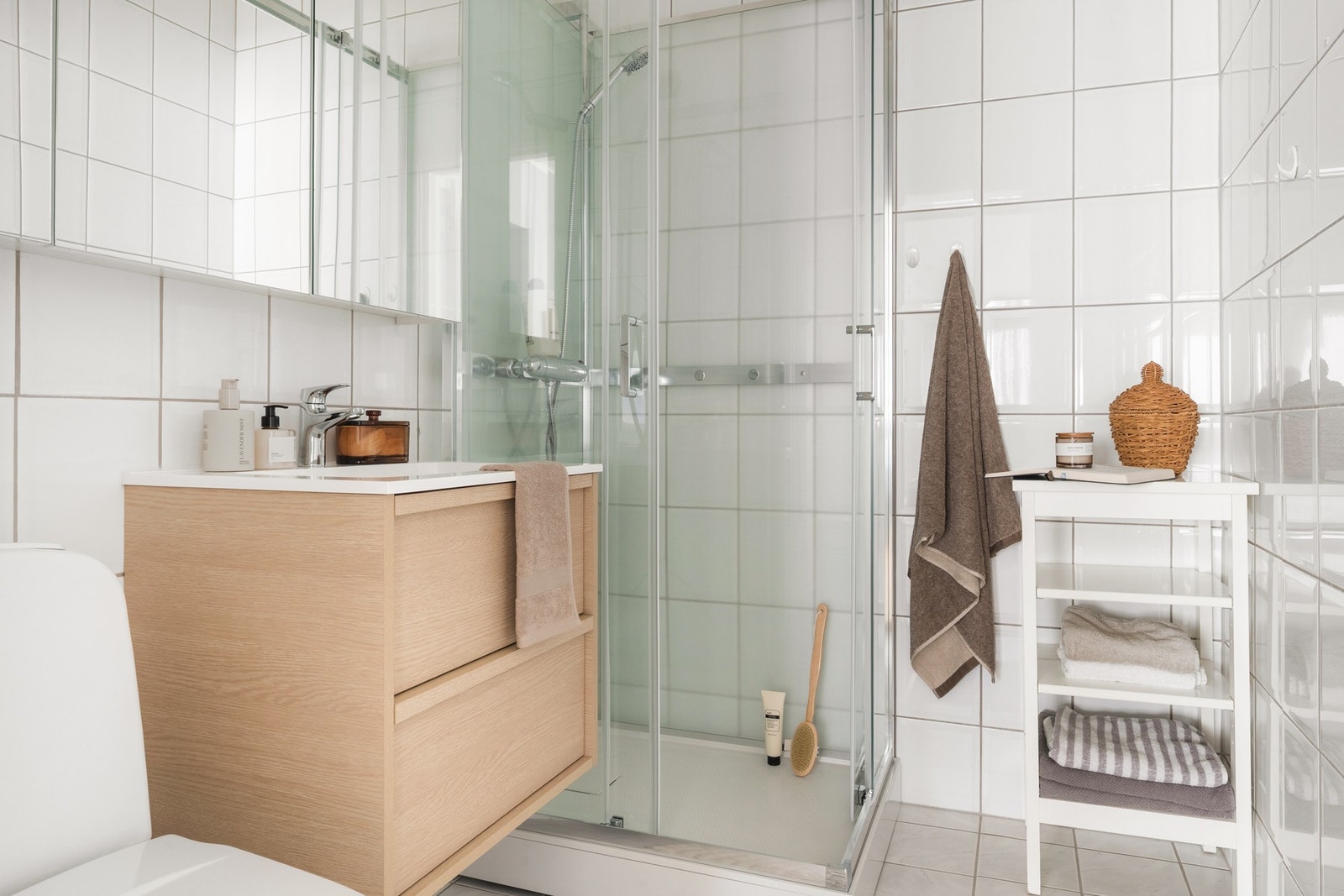 Badet måler 3,2 kvm og er innredet med dusjkabinett, speilskap, baderomsinnredning og toalett. Galleribilde