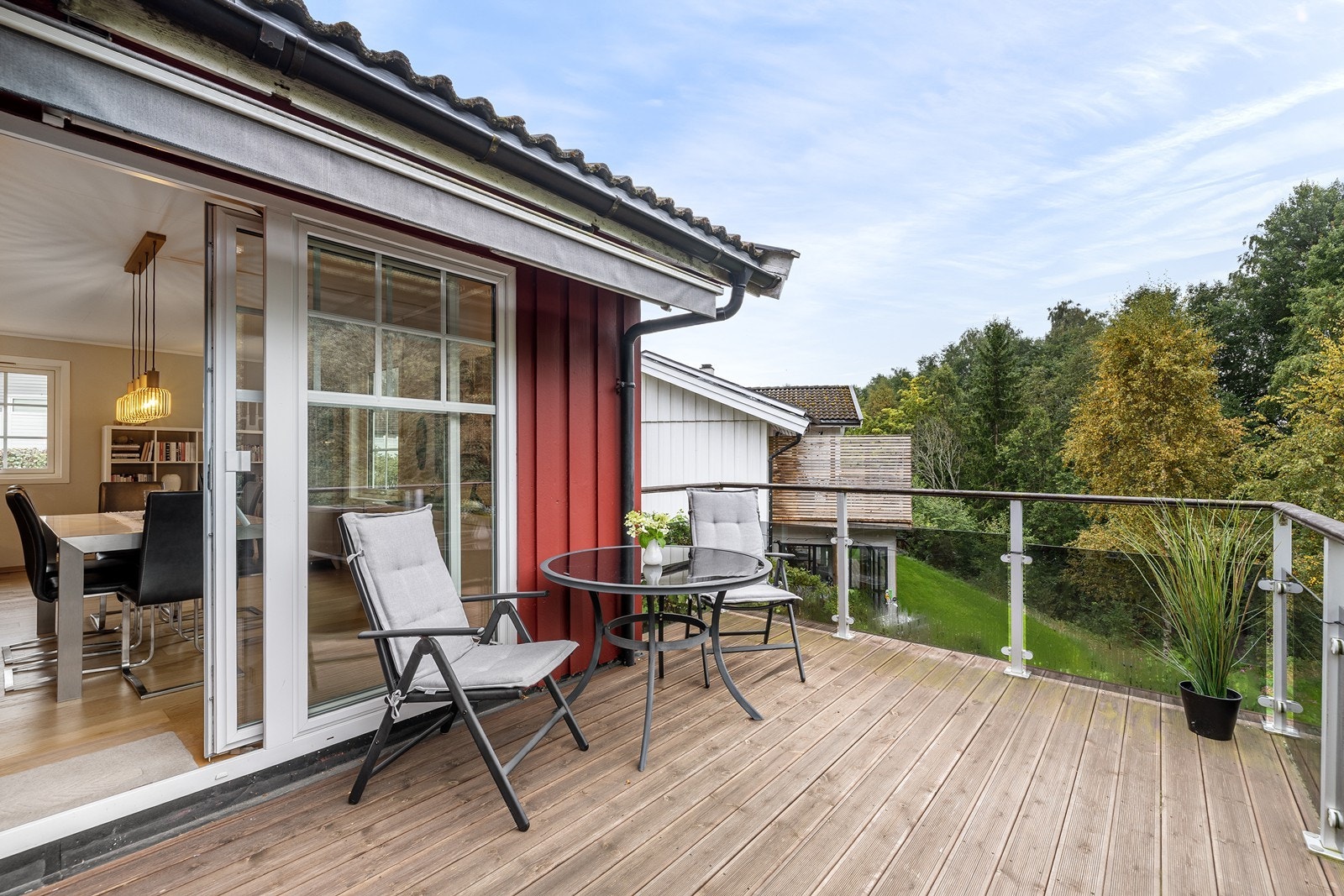 Balkong med glassrekkverk, sittegruppe og flott utsikt over grøntområdet. Galleribilde