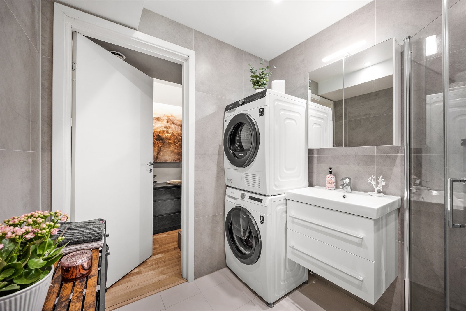 Badet er flislagt På gulv og vegger med varme i gulv. Det er lagt opp til bruk av både vaskemaskin og tørketrommel Galleribilde