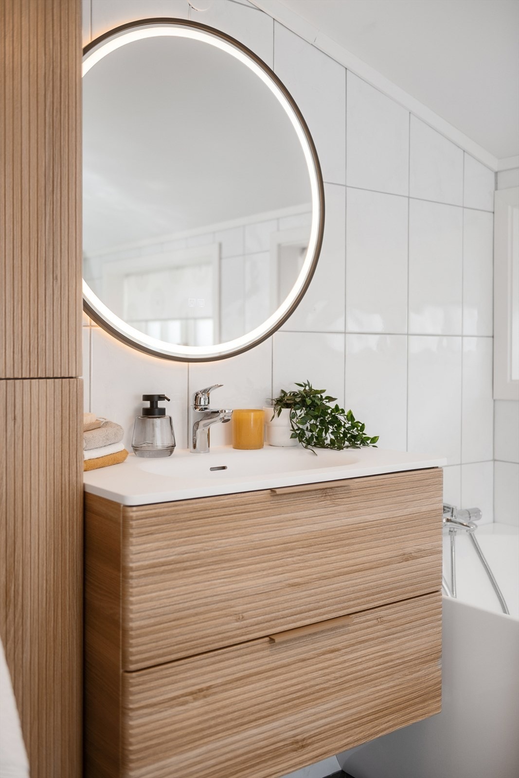 Moderne servantinnredning med nedfelt vask, speil med belysning og god oppbevaringsplass. Galleribilde