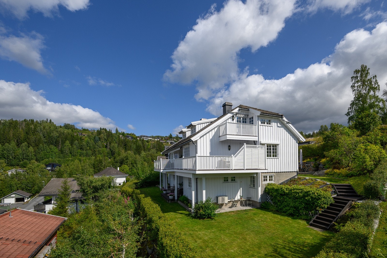 Boligen har en klassisk arkitektur med halvvalmet tak og stående bordkledning. Galleribilde