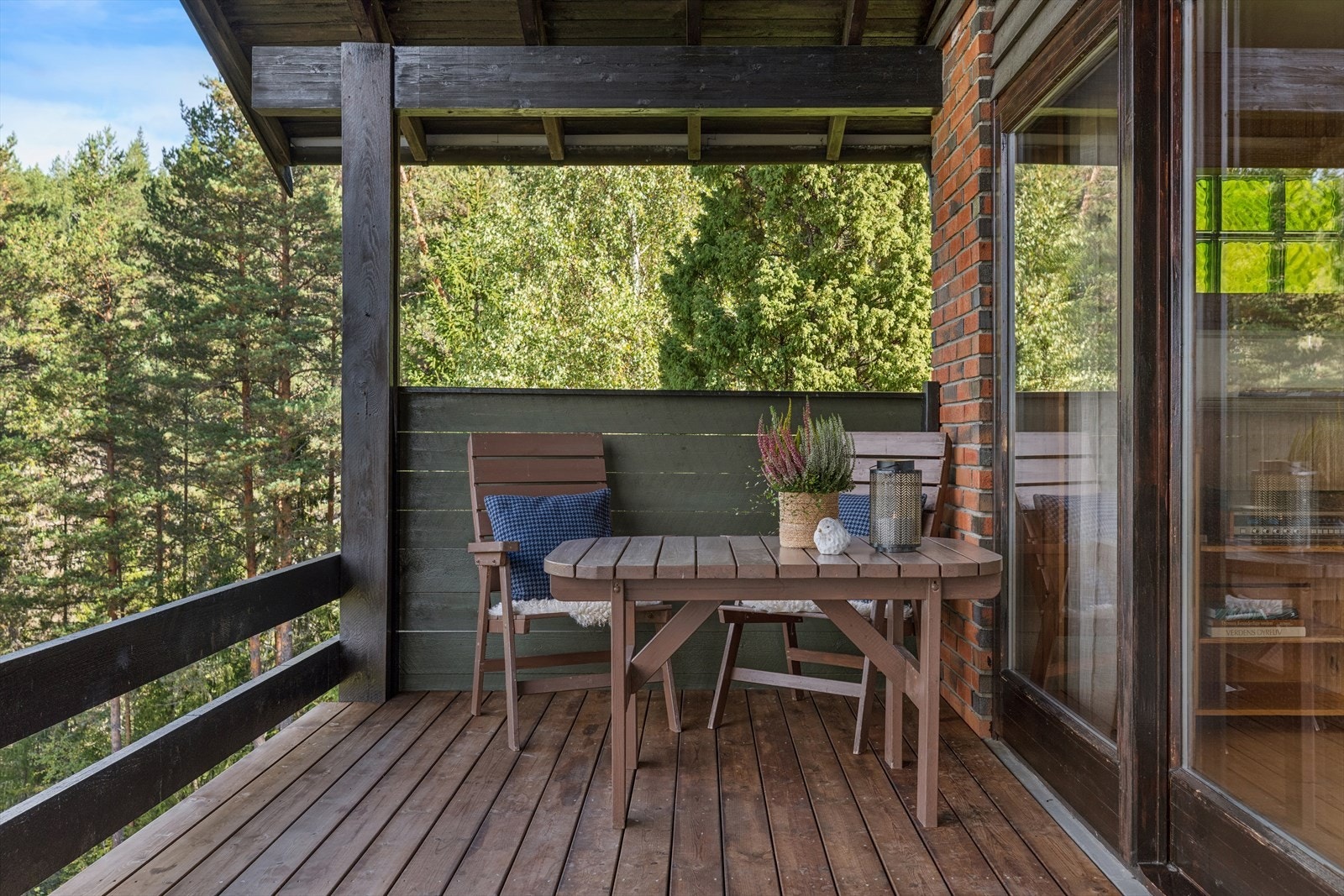Overbygd veranda med betongdekke, terrassebord og skjermende levegg. Galleribilde