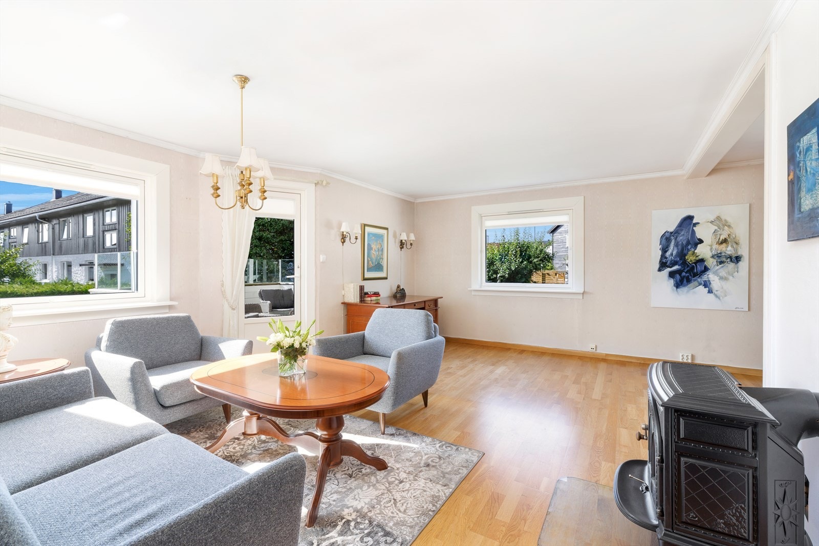 Lys og pen stue med plass til både sofagruppe og spisebord i overgangen mot kjøkkenet. Peisen sørger for rikelig med varme og hygge på kaldere dager. Galleribilde