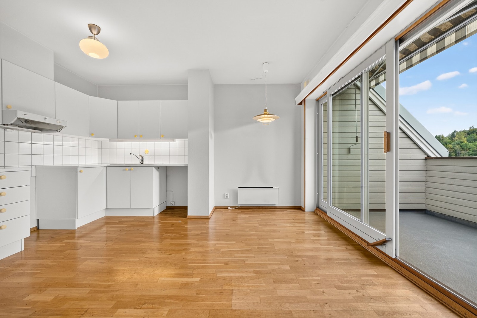 Innredningen har hvite, slette fronter og laminert benkeplate med nedfelt vaskekum. Galleribilde