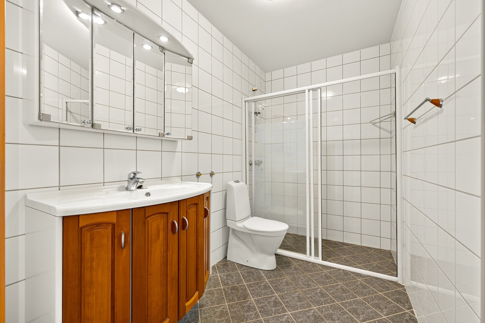 Dusjen er plassert i enden av badet og har skyvedør som gir god plassutnyttelse og enkel tilkomst. Det er opplegg og plass for vaskemaskin. Galleribilde
