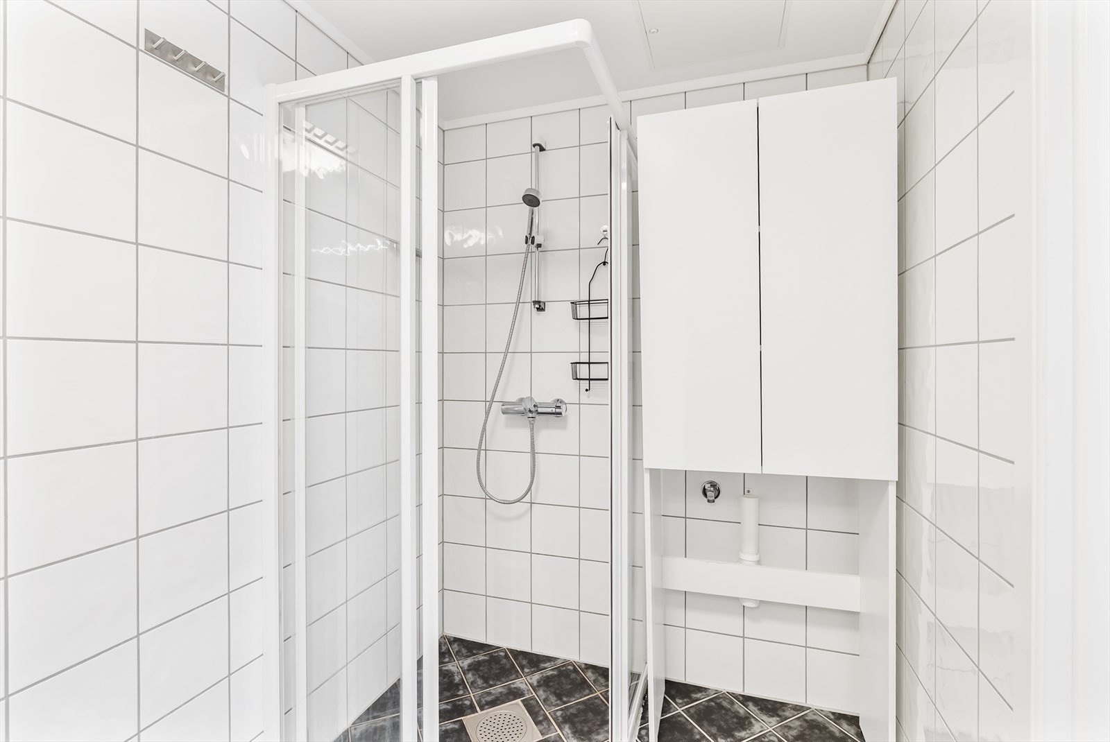 Baderommet har opplegg for vaskemaskin og ekstra veggmontert skap. Galleribilde