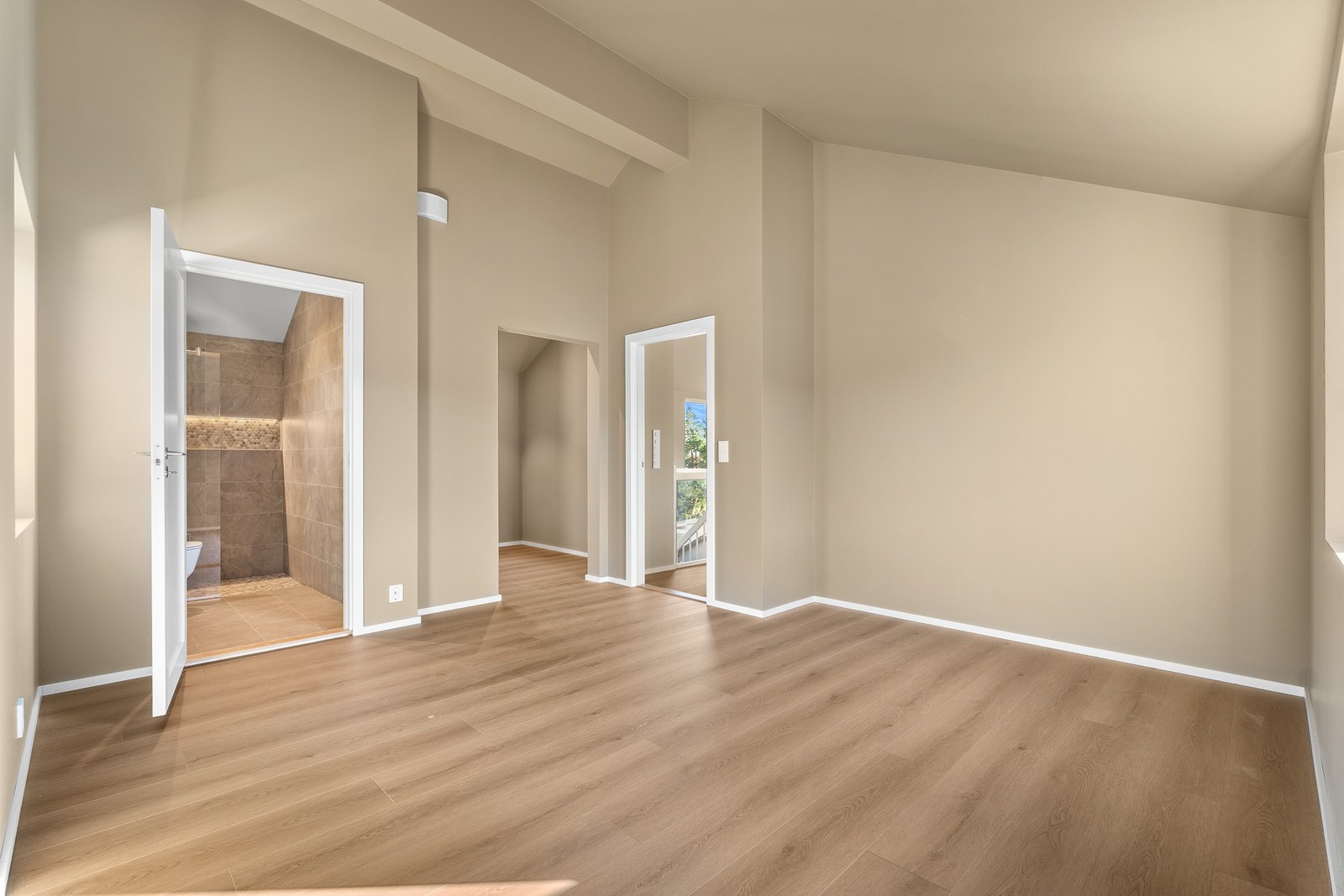 Fra rommet er det direkte adkomst til eget en-suite bad og walk-in closet, som gir en privat og komfortabel foreldresone. Galleribilde